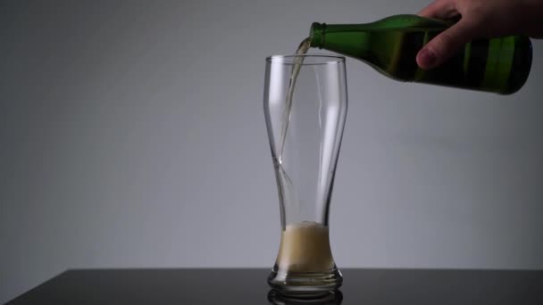 Het gieten van bier in het glas in slow motion medium shot — Stockvideo