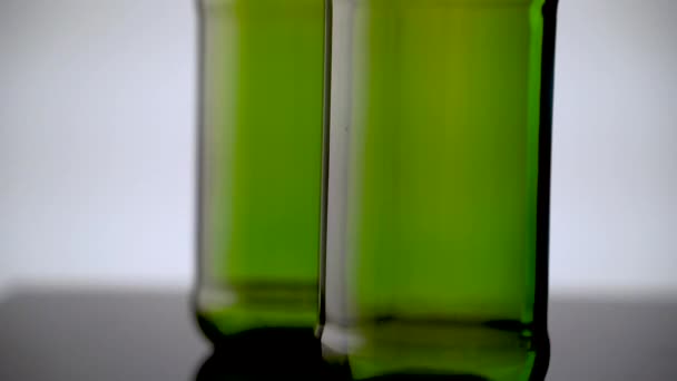 Moving close-up from the bottom up of green beer bottles — Stock Video