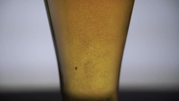 Nahaufnahme eines Bierglases mit aufsteigenden Blasen, Schuss von unten nach oben — Stockvideo