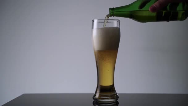 Человек наливает пиво из бутылки в стакан — стоковое видео