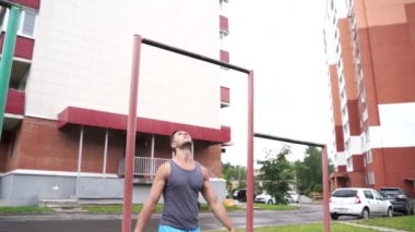 Genç adam açık havada yatay bir barda bar-up yapıyor