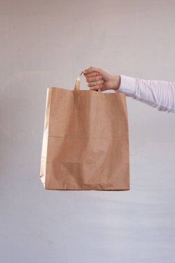 Genç kadın kahverengi bir teslimat zanaat kağıt torba taşıyor