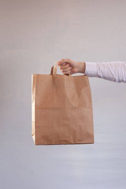Genç kadın kahverengi bir teslimat zanaat kağıt torba taşıyor