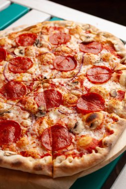 Eritilmiş peynir ve mantar ile acı pepperoni pizza yakın 