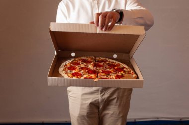 Genç adam champignon mantar ile acı pepperoni pizza ile bir teslimat karton kutu açıyor