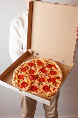 Genç adam champignon mantar ile acı pepperoni pizza ile bir teslimat karton kutu açıyor