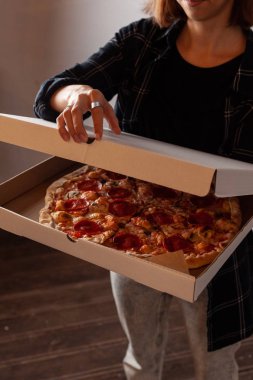 Genç kadın champignon mantar ile acı pepperoni pizza ile bir teslimat karton kutu açıyor