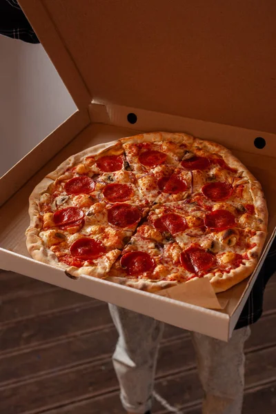 Genç kadın champignon mantar ile acı pepperoni pizza ile bir teslimat karton kutu açıyor