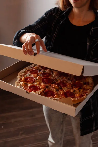 Genç kadın champignon mantar ile acı pepperoni pizza ile bir teslimat karton kutu açıyor