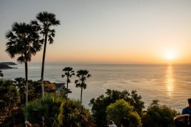 Tayland, 2020: yukarıdan insansız hava aracı, günbatımında ağaçlar ve kayalıklarla panoramik okyanus manzarası