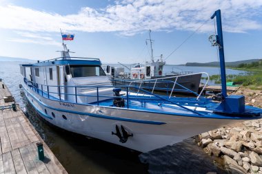 Rusya, Irkutsk bölgesi, Olkhon, Temmuz 2020: Üzerinde Rus bayrağı olan küçük bir motorlu tekne, pürüzsüz bir gölün üzerinde duruyor.