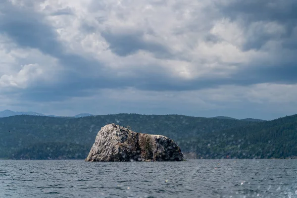 ロシア イルクーツク地域 バイカル湖 2020年7月 上の劇的な雲を持つ湖の中心部にある巨大な灰色の岩 — ストック写真