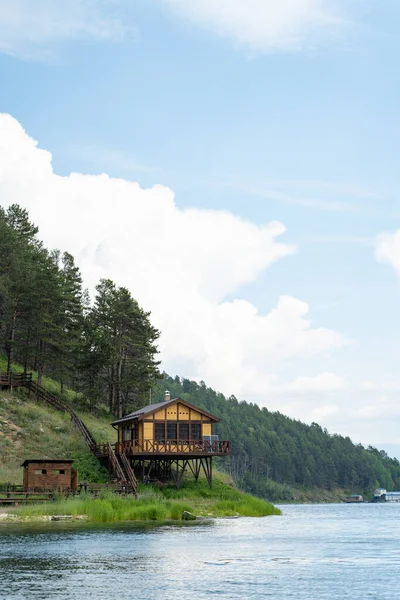 深い森を背景にバイカル湖のシェアにある小さなかわいい木製の小屋 — ストック写真
