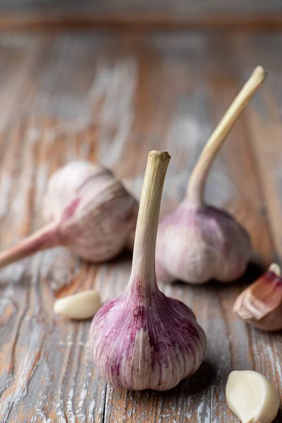 Hafif ahşap arka planda üç baş sarımsak. Yakın plan.