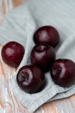 Keten kumaşta mor erikler, yakın çekim, seçici odaklanma.