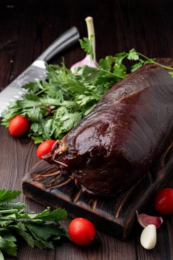 Sulu fileto, koyu bir arka planda otlar ve maydanozla birlikte.