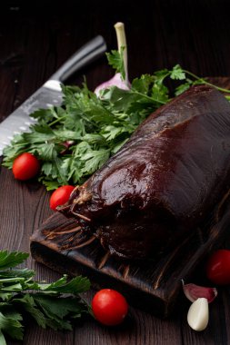 Sulu fileto, koyu bir arka planda otlar ve maydanozla birlikte.