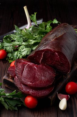 Stüdyo fotoğrafı, ham fileto, dilimlenmiş ve otlarla çevrili, koyu arkaplan 