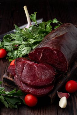 Stüdyo fotoğrafı, ham fileto, dilimlenmiş ve otlarla çevrili, koyu arkaplan 