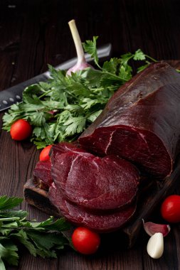 Stüdyo fotoğrafı, ham fileto, dilimlenmiş ve otlarla çevrili, koyu arkaplan 