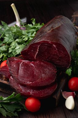 Koyu et filetosu, kesilmiş ve otlarla çevrili, koyu ahşap arka planda, bir katalog için fotoğraf