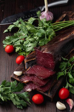 Tütsülenmiş ve kurutulmuş mignon, sulu ve lezzetli, esrarlı arka planda otlar ve baharatlarla, reklam fotoğrafı