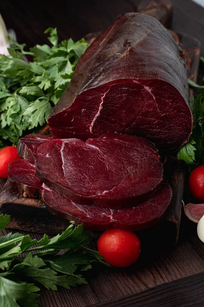 Koyu et filetosu, kesilmiş ve otlarla çevrili, koyu ahşap arka planda, bir katalog için fotoğraf