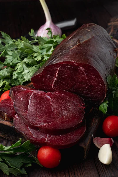 Koyu et filetosu, kesilmiş ve otlarla çevrili, koyu ahşap arka planda, bir katalog için fotoğraf