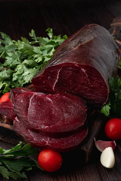 Koyu et filetosu, kesilmiş ve otlarla çevrili, koyu ahşap arka planda, bir katalog için fotoğraf