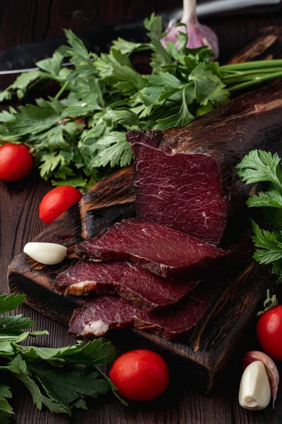 Tütsülenmiş ve kurutulmuş mignon, sulu ve lezzetli, esrarlı arka planda otlar ve baharatlarla, reklam fotoğrafı