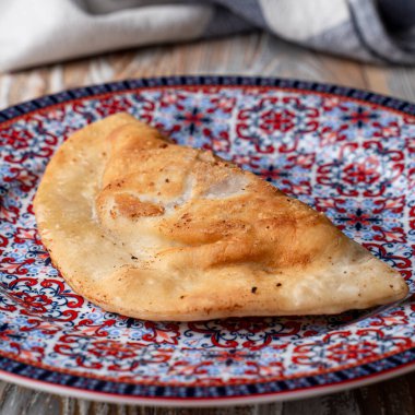 Doğulu bir tabakta altın bir cheburek yakın plan