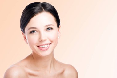 Güzel bir gülümseme ile genç bir kadın. Güzellik Portresi. Mükemmel cilt. Boş alan ile nötr arka plan