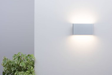 Işık duvarında modern bir duvar lambası. İçerideki boş alan ve dekor