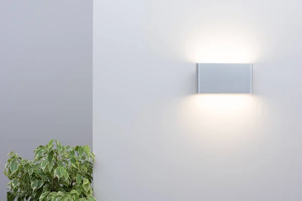 Modern wall lamp on a light wall. Free space and decor in the interior