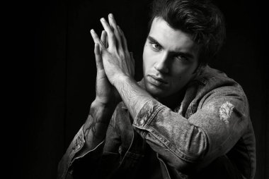 Portre siyah bir arka plan üzerinde siyah beyaz erkek portresi. Genç yakışıklı poz ve kameraya bakarak adam. Moda fotoğraf profesyonel model