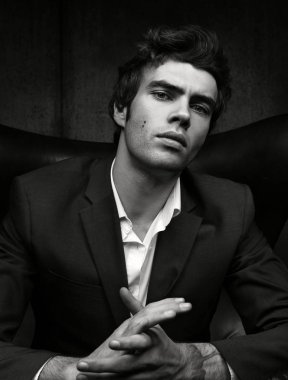 Siyah ve beyaz ceket ve gömlek kendine güvenen adam portresi. Koyu arka plan