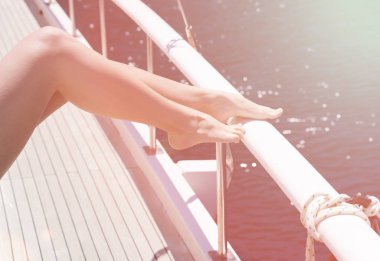 Güneşin güvertede güneşlenin. Kadın ayakları portre. Denizde tatil yaz