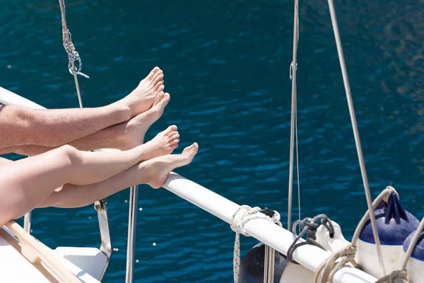 在游艇上度过暑假 蓝海背景中的女性和男性脚 — 图库照片