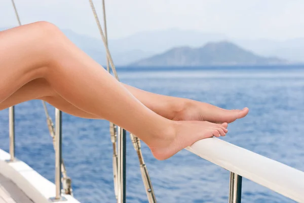 美丽的女性脚对海巡航风景 在游艇上休息 背景中的海和山 — 图库照片