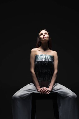 Işıkta arayan genç kadın silüeti. Portre siyah arka plan üzerine düşük anahtar içinde. Boş alanın görüntü