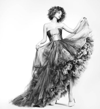 Siyah ve beyaz moda portre içinde bir güzel genç bir kadın. Kalın kıvırcık saç ve makyaj. Model beyaz bir arka plan üzerinde poz