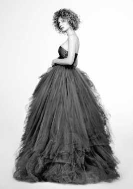 Siyah ve beyaz moda uzun gri elbiseli güzel genç kadın portresi. Tarafsız beyaz arka plan