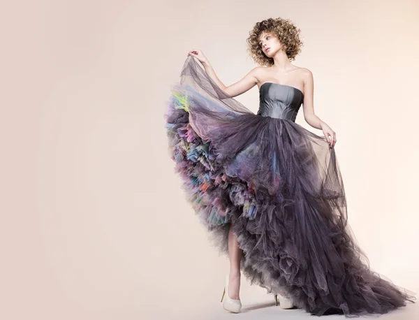Moda portre ile özgür yer. Çok güzel bir elbise genç kadın. Kalın kıvırcık saç ve makyaj. Model beyaz arka plan üzerinde poz