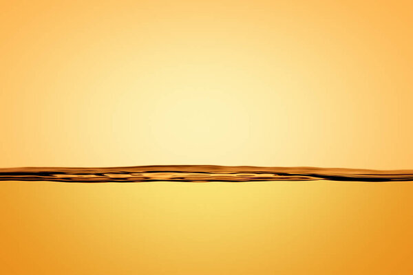 The cross section of the surface of calm water in Golden color. Close-up backgroun
