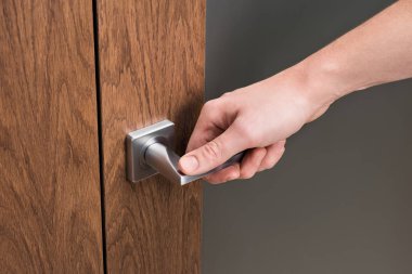 Kapı kolu üzerinde bir erkek eli. Koyu meşe ve buzlu glas