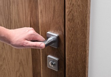 Adam kapıyı açar. Yakın - up el ve kapı kolu. Karanlık sağlam meşe kapı