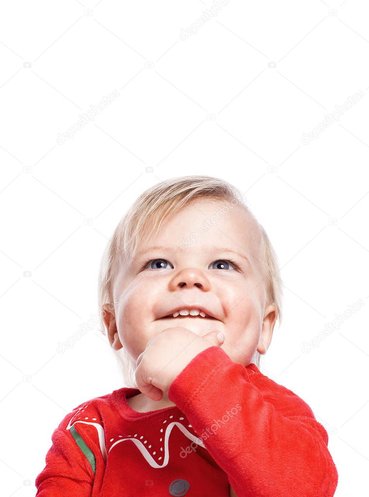 The child looks up dreamily. Waiting for Christmas. Think of gifts. One isolated on white background with free spac