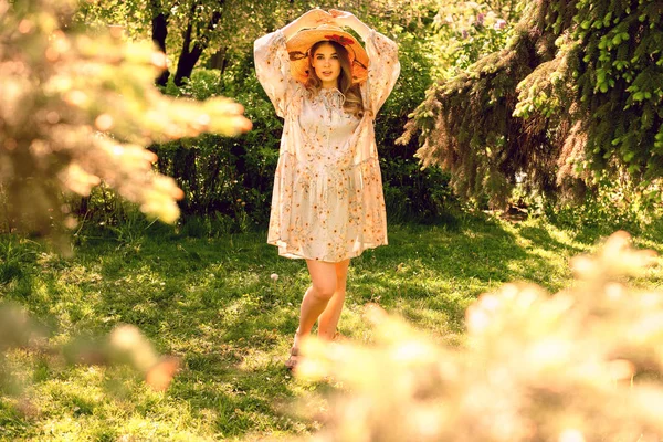 Mooie jonge vrouw in het bos. Muts en lichte zomer jurk — Stockfoto