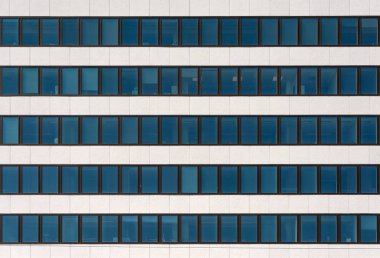 Modern bir ofis binasının ön cephesinin bir parçası. Pencereler ve hafif dekoratif taş