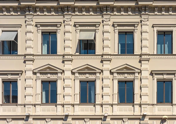 Fragmento da fachada do edifício histórico da cidade. Janelas com cornijas e decoração — Fotografia de Stock